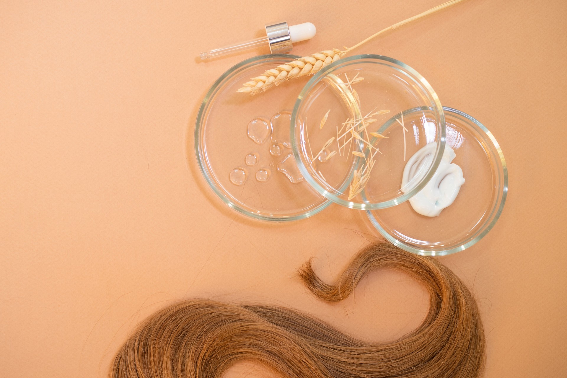 Eco-friendly and modern cosmetics for hair care, a set of ingredients and bottles on a brown background.